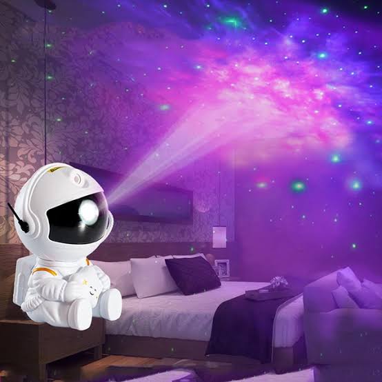 Astronauta con proyector de estrellas, galaxia